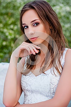 Portrait of a young beautiful woman in a white corset and with large white angel wings behind her back