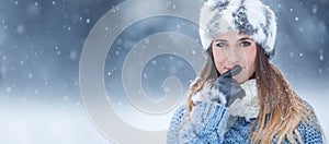 Portrait of young beautiful woman in winter clothes and strong snowing