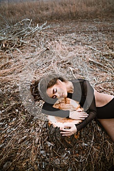 Portrait of young beauty woman with wooden crown hugging a tree