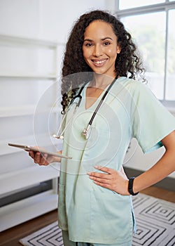 Portrait of a young biracial female doctor, using digital tablet, eHealth