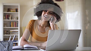 Portrait of young black business woman in office or at home using laptop and having phone call Spbd