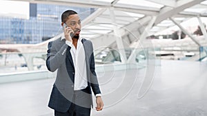 Portrait Of Young Black Businessman Talking At Mobile Phone At Airport
