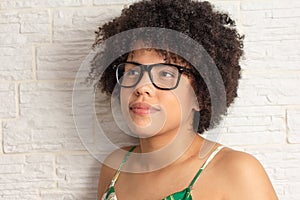 Portrait of Young black woman with afro hairstyle wearing glasses, looking to the side