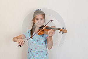 Portrait of a young blond teenage girl playing violin. Girl playing the violin