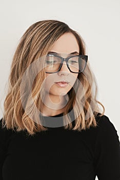 Portrait of a young blond woman with long bob haircut wearing eyeglasses