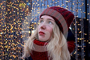 Portrait of a young blond woman wearing red knitted hat and scarf