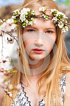 Portrait of a young blonde girl posing in spring park