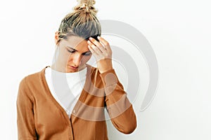 Portrait of young blonde woman having headache migraine. Female student have stress and feels worried. Healthcare and medicine