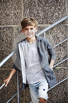 Portrait of a young boy against brick wall