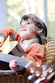 Portrait of young boy playing acoustic guitar