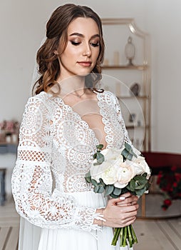 Portrait of a young bride with a bouquet and in a wedding dress in boho style