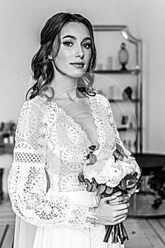 Portrait of a young bride with a bouquet and in a wedding dress in boho style