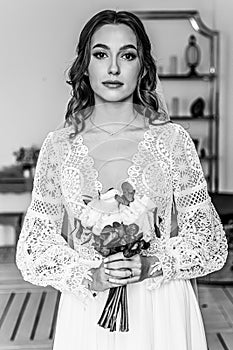 Portrait of a young bride with a bouquet and in a wedding dress in boho style