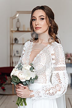 Portrait of a young bride with a bouquet and in a wedding dress in boho style