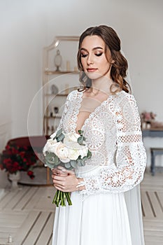 Portrait of a young bride with a bouquet and in a wedding dress in boho style