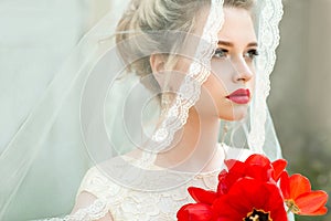 Portrait of Young Bride with Professional Wedding Bridal Makeup and Hair Style. Beautiful Woman with Bouquet of Tulips