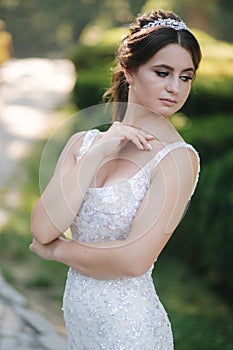 Portrait of young bride in white wedding dress outdoors. Fashion makeup