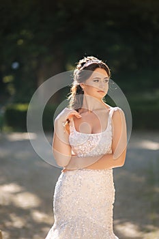 Portrait of young bride in white wedding dress outdoors. Fashion makeup