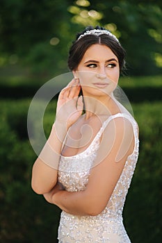 Portrait of young bride in white wedding dress outdoors. Fashion makeup