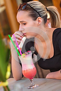 Portrait of young brunette beauty with a drink on the table