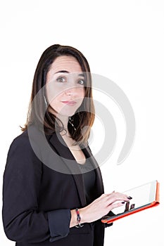 Portrait of young brunette businesswoman standing with tablet in white wall background