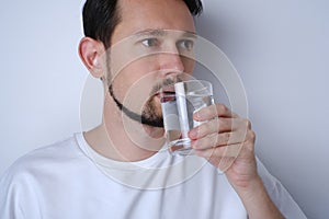 portrait of a young brunette man drinking water