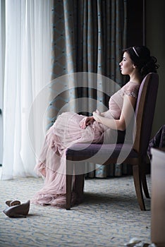 Portrait of a young brunette woman in a beautiful dress with make-up and hairstyle