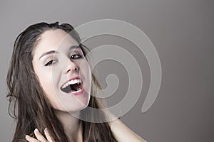 Portrait of a young brunette woman making faces with different e