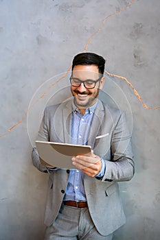 Portrait of young business man working on digital tablet