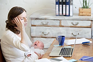 Portrait of young business mom having headache because of crying