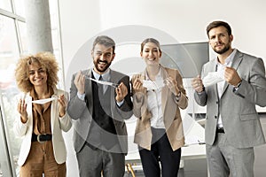 Portrait of young business people taking off their protective face masks