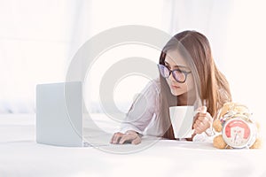 Portrait of a young business woman ,laptop,cup of coffee. Business concept a laptop drinking coffee with her computer on the bed