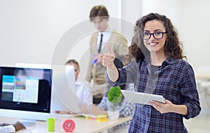 Portrait of young business woman at modern startup office interior, team in meeting in background