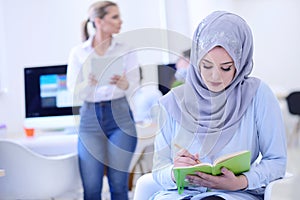 Portrait of young business woman at modern startup office interior, team in meeting in background