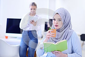 Portrait of young business woman at modern startup office interior, team in meeting in background