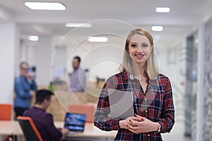 portrait of young business woman at office with team in background