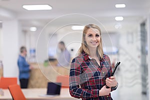 portrait of young business woman at office with team in background