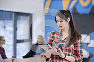 portrait of young business woman at office with team in background