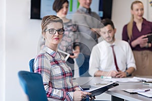 Portrait of young business woman at office with team on meeting