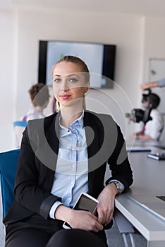 Portrait of young business woman at office with team on meeting