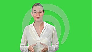 Portrait of a young business woman presenting something by a hand on a Green Screen, Chroma Key.