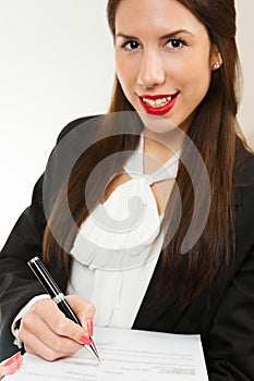 Portrait of a young business woman, signing contract