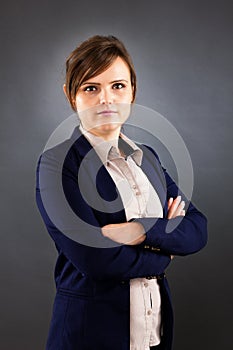 Portrait of young business woman standing with arms crossed
