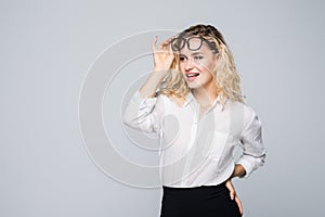Portrait of young business woman take out glasses isolated on grey background.