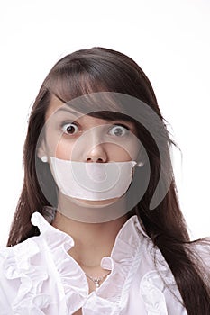 Portrait of young business woman with taped mouth