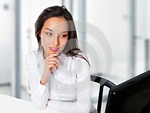 Portrait of a young business woman using computer at office