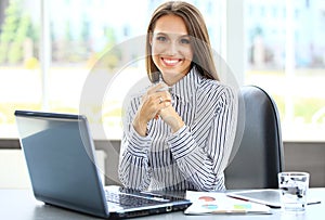 Portrait of a young business woman using laptop