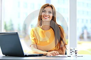 Portrait of a young business woman using laptop