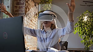 Portrait of a young business woman who using virtual reality headset in the office. Beautiful girl sitting at the
