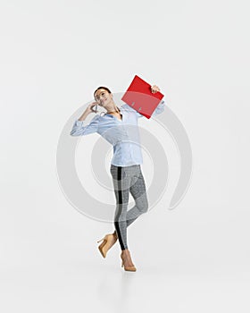 Portrait of young business woman, worker talking on a phone isolated over white background